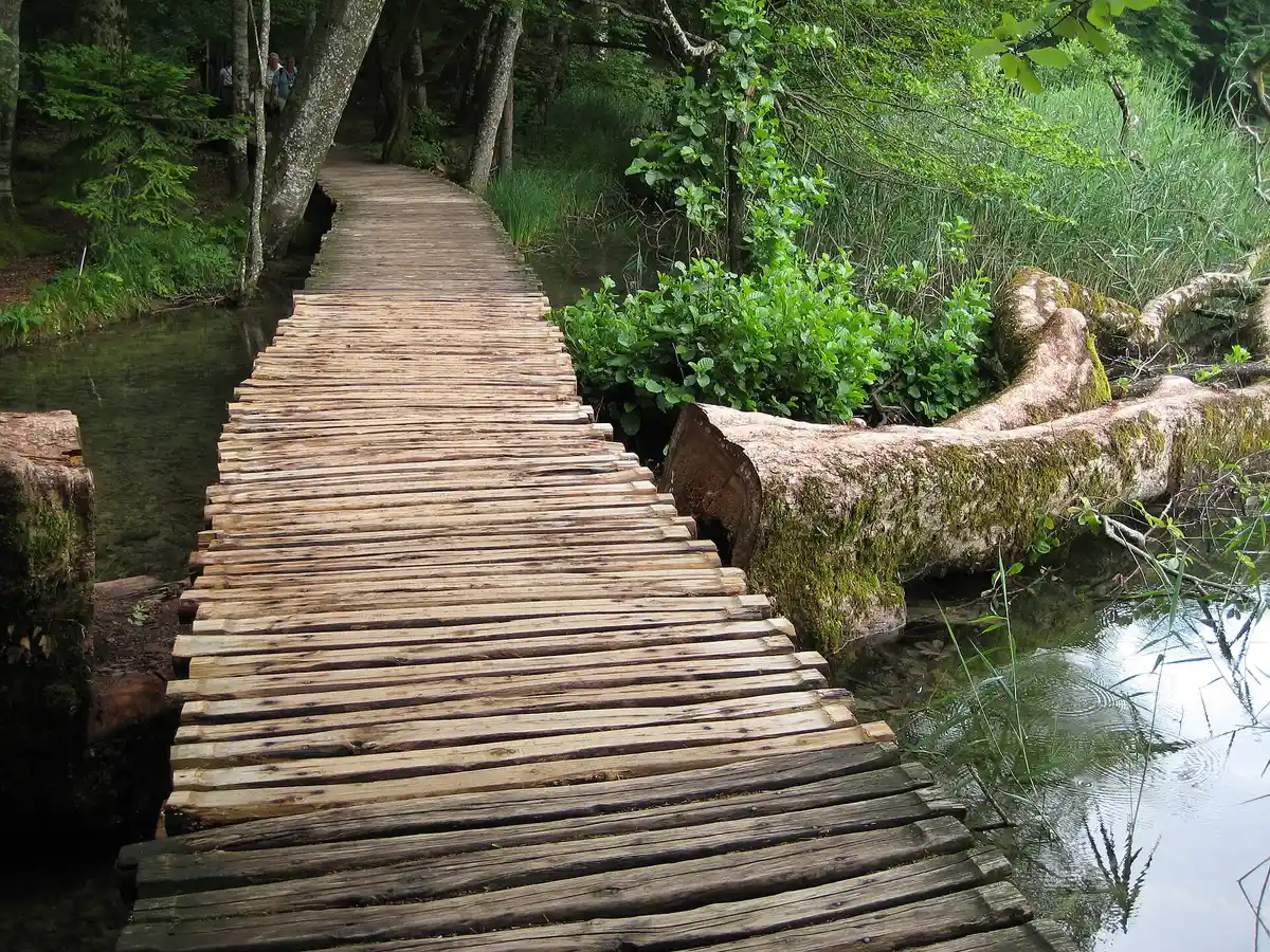 Wooden boardwalk threading between waterfalls on a Plitvice Lakes National Park tour, Croatia