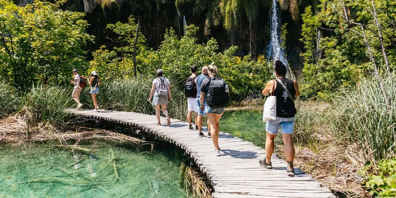 Wooden boardwalk crossing turquoise lakes on a Plitvice Lakes National Park tour from Split, Croatia
